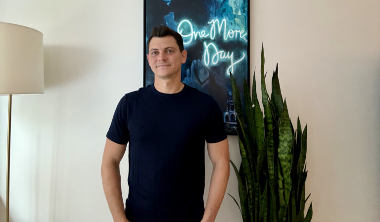 Nomadic Matt posing with his Unbound Merino clothing in his apartment